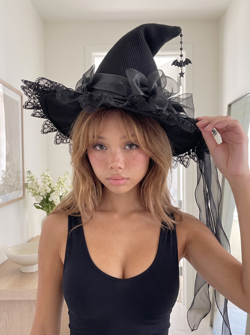 Close-up of the witch hat showing the knit crown, lace brim and organza bow